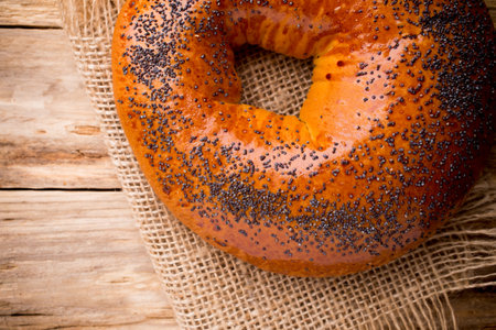 Freshly baked bread with poppy seeds on a wooden background.の写真素材