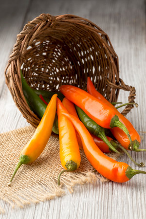 Chili pepper mix on a wooden background.の写真素材