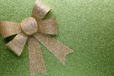 Christmas bow golden color. On colored paper background.の写真素材
