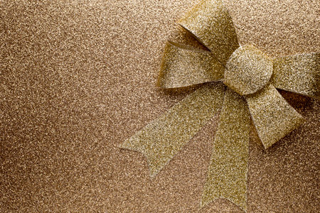Christmas bow golden color. On colored paper background.の写真素材