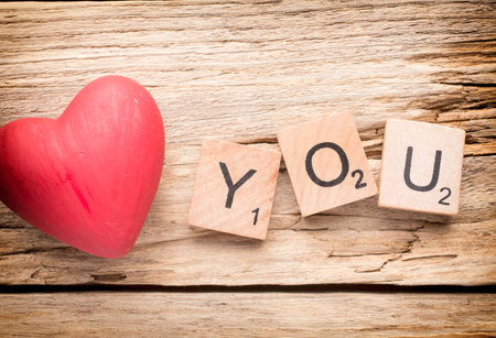 Red heart on old wooden background - Stock Image. I love you, cast out of wood kubik.の写真素材