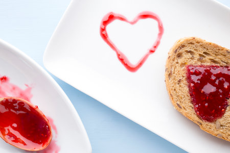 Grain slice of bread with jam heart shape.