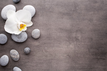 Spa stones and white orchid on the grey background.の写真素材