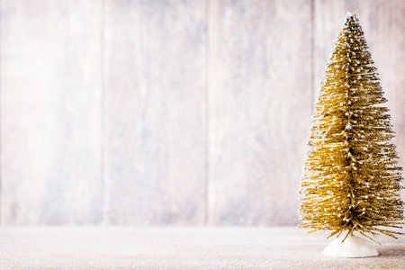 Golg and green christmas tree on a wooden background.の写真素材