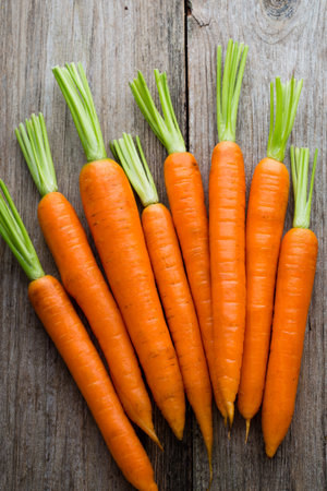 Fresh carrots bunch on rustic wooden background.