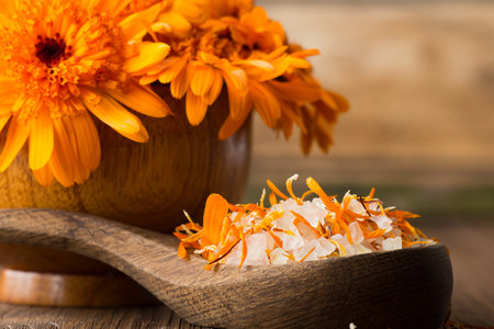 Homeopathic medicine, calendula dry flowers and wooden surface.の写真素材
