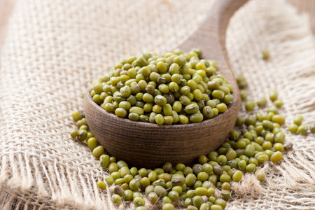 Chinese beans in wooden spoon on wooden surface. Eco product.の写真素材