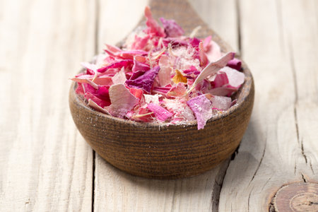 Homeopathic medicine; flower dry petals and spoon; wooden surface.の写真素材