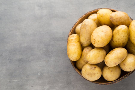 Potato on the bowl, gray background.の写真素材