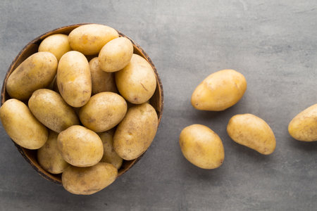 Potato on the bowl, gray background.の写真素材