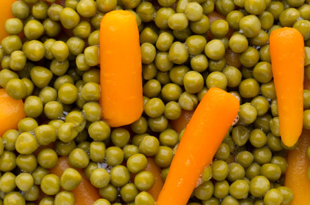 Carrots with green peas vegetable background.の写真素材
