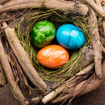 Easter eggs in the nest on rustic wooden background