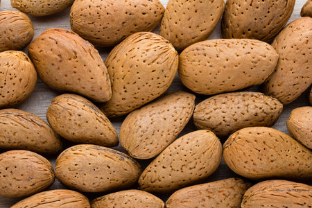 Group of almond nuts with leaves.Wooden background.