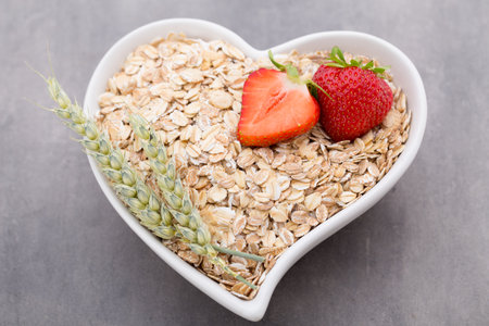Fried oat flakes in a heart bowl.の写真素材
