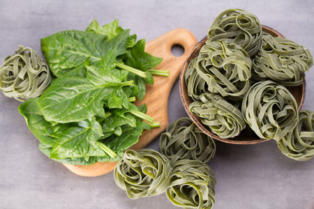 Fresh spinach with green pasta on a gray background.の写真素材