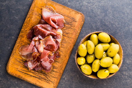 Italian prosciutto crudo or jamon with spice, olive, rosemary. Raw ham.の写真素材