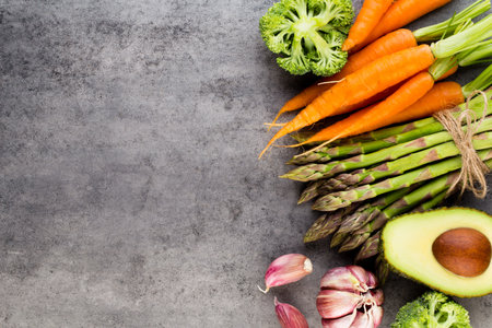 Banches of fresh green asparagus,  and vegetables on wooden background, top viewの写真素材