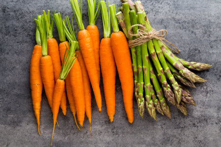 Banches of fresh green asparagus,  and vegetables on wooden background, top viewの写真素材