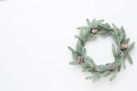 Christmas greeting card. Wreath decoration on white wooden background. New Year concept. Copy space....