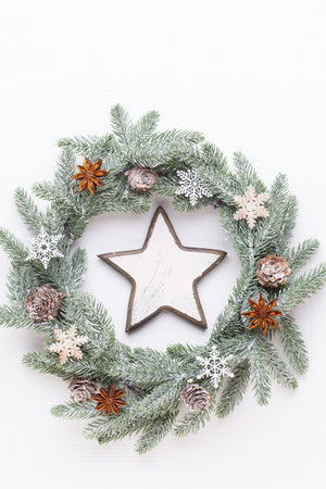 Christmas greeting card. Wreath decoration on white wooden background. New Year concept. Copy space.  Flat lay. Top view.の写真素材