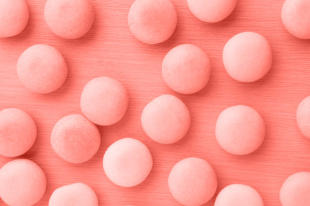 Small round candy living coral pastel background.