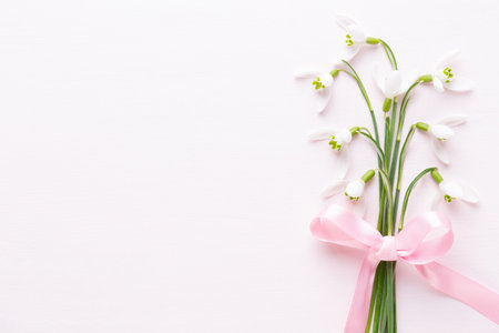 Fresh snowdrops on pink background with place for text. Spring greeting card. Flat lay.の写真素材