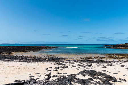 Lanzarote at the base of huge volcanic cliffs, from Caleton Blanco beach.
