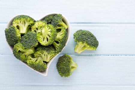 Fresh broccoli in a heart shaped bowl on a wooden background.の写真素材