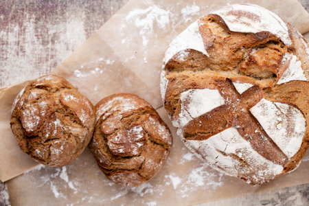 Freshly baked bread on dark gray kitchen table, top view.