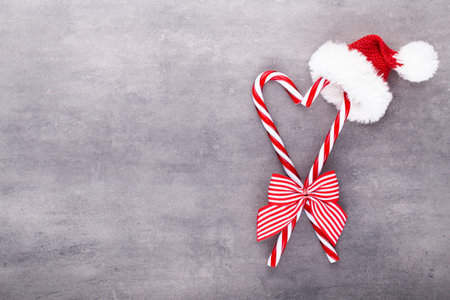 Christmas candy canes, stick and decor on color background. Sweet Christmas Card - Candy Canes With Ribbon - Image.の写真素材