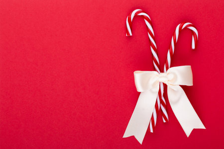 Christmas candy canes, stick and decor on color background. Sweet Christmas Card - Candy Canes With...