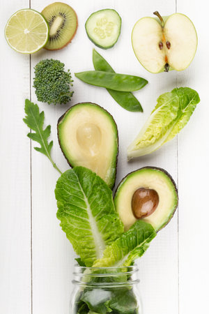 Glass jar mugs with green health vegetables lettuce leaves, lime, apple, kiwi, avocado, food concept.の写真素材