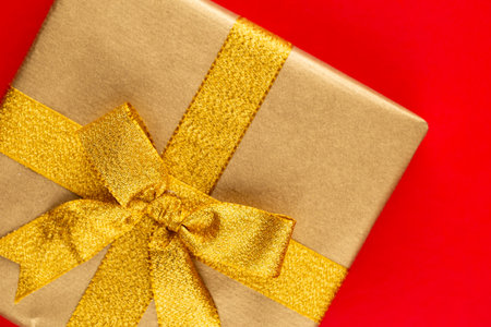 Top view of arranged wrapped christmas gift boxes with ribbons on red tabletop.の写真素材