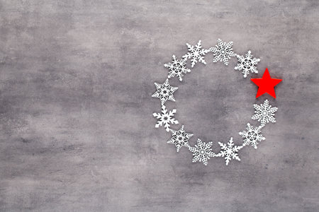 Christmas composition. White snow flakes wreath decorations on gray background. Christmas, winter, new year concept. Flat lay, top view, copy.の写真素材