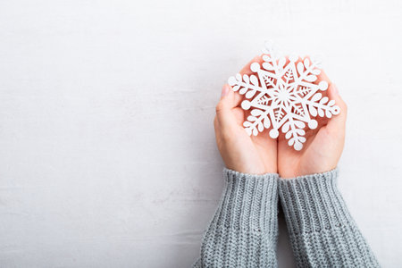 Vintage Christmas background with Christmas decoration in hand. Christmas greeting card. Festive decoration on gray background. New Year concept. Copy space. Flat lay. Top view.の写真素材