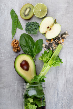 Glass jar mugs with green health vegetables lettuce leaves, lime, apple, kiwi, avocado, food concept.の写真素材