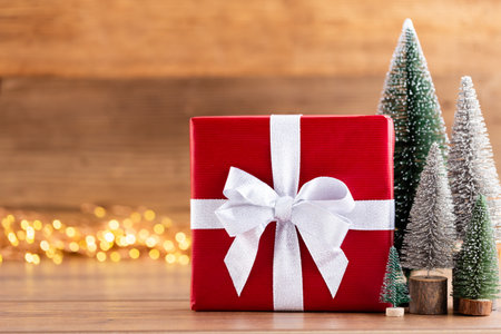 Christmas gift boxes with ribbons and tree on bokeh background.の写真素材