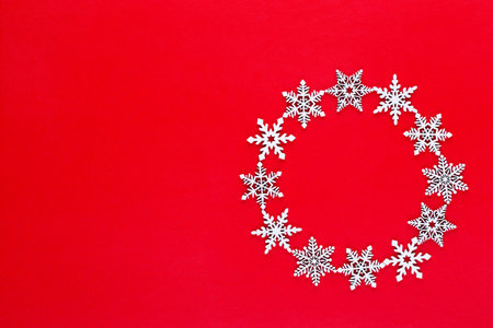 Christmas composition. White snow flakes wreath decorations on red background. Christmas, winter, new year concept. Flat lay, top view, copy.の写真素材