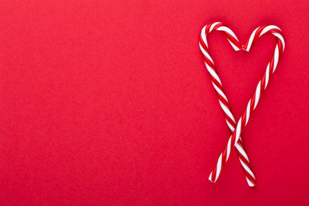 Christmas candy canes, stick and decor on color background. Sweet Christmas Card - Candy Canes With Ribbon - Image.の写真素材