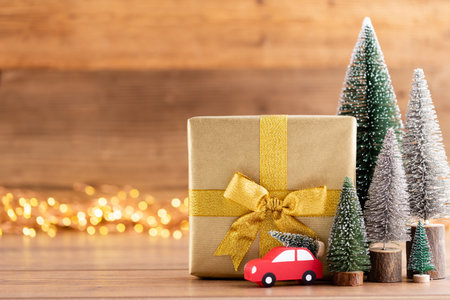 Christmas gift boxes with ribbons and tree on bokeh background.の写真素材