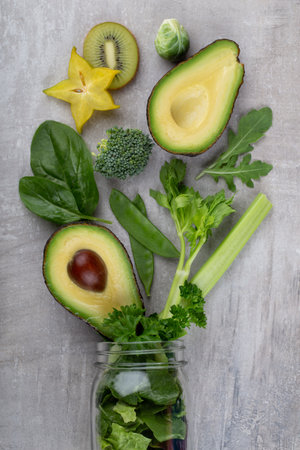 Glass jar mugs with green health vegetables lettuce leaves, lime, apple, kiwi, avocado, food concept.の写真素材