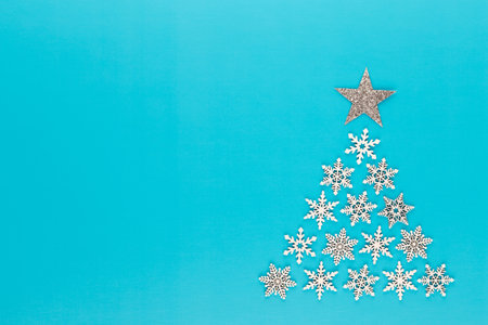 Christmas tree made from white snow flake decorations on red  background with empty copy space for text. New year and christmas postcard.の写真素材