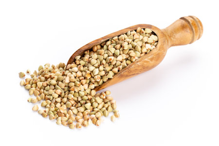 Raw buckwheat and wooden spoon on white background.の写真素材