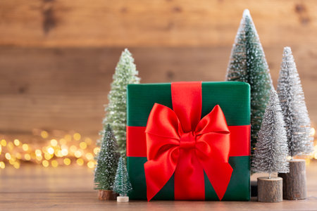 Christmas gift boxes with ribbons and tree on bokeh background.の写真素材