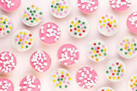 Multiple colorful nicely decorated muffins on a white background, top view.の写真素材