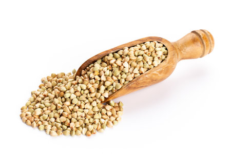 Raw buckwheat and wooden spoon on white background.の写真素材