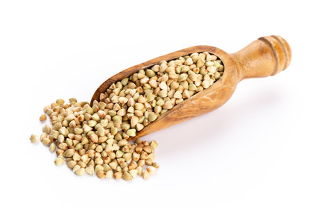 Raw buckwheat and wooden spoon on white background.の写真素材