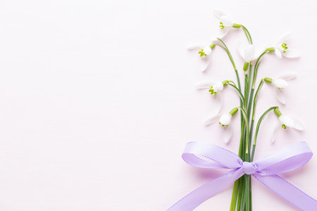 Fresh snowdrops on pink background with place for text. Spring greeting card. Flat lay.の写真素材