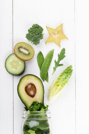 Glass jar mugs with green health vegetables lettuce leaves, lime, apple, kiwi, avocado, food concept.の写真素材