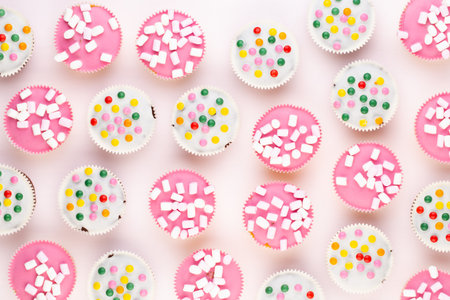 Multiple colorful nicely decorated muffins on a white background, top view.の写真素材